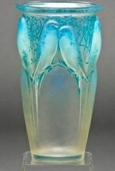 a glass vase with two birds on it