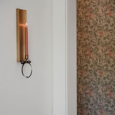 a candle is lit on the wall next to a door handle with a ring around it