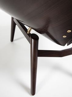 a close up of a wooden chair on a white surface with no one around it