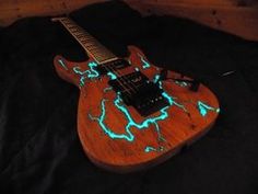 an electric guitar with glow in the dark paint on it's body and neck