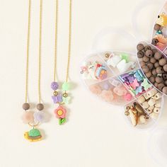 two necklaces are shown in the shape of heart shaped containers with beads and charms