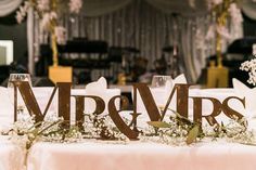 the table is set up for a wedding reception with mr and mrs letters on it