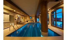 a large indoor swimming pool surrounded by windows