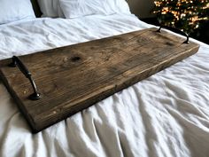 a wooden tray sitting on top of a bed next to a christmas tree in the background