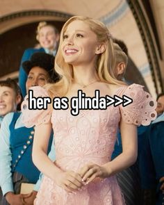 a woman standing in front of a group of people with the words her as glinda > >