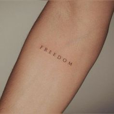 a person's arm with the word freedom written on it, in black ink