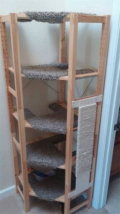 a wooden shelf filled with lots of items next to a door in a room that has carpet on the floor