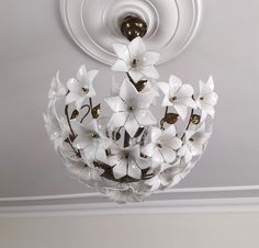 a chandelier with white flowers hanging from the ceiling