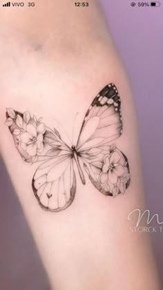 a small butterfly tattoo on the right side of the arm, with flowers around it