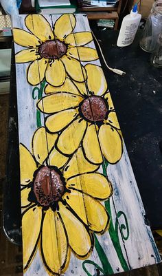 a painted wooden board with yellow flowers on it