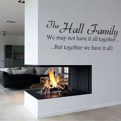 a living room with a fire place next to a wall that says the hall family we may not have it all together but together we have it all