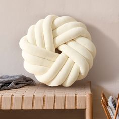 a large white knot sitting on top of a wooden bench next to a book shelf