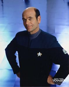 a man in a star trek uniform standing with his hands on his hips and looking at the camera