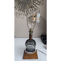 a lamp that is sitting on top of a wooden stand with a light bulb attached to it