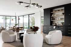 a living room filled with white furniture and lots of glass doors leading to an outside patio