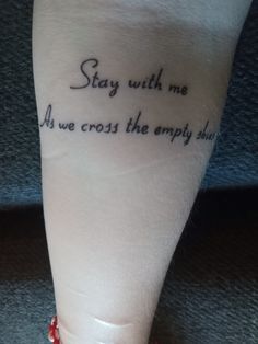 a woman's foot with a tattoo saying stay with me and we cross the empty path