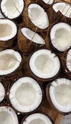 coconuts that have been cut in half on a cutting board