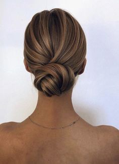 the back of a woman's head with her hair in a low bun