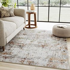 a living room area with a couch, coffee table and large window looking out onto the countryside