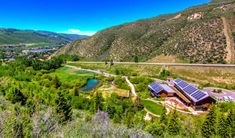 an aerial view of a house in the mountains with solar panels on it's roof