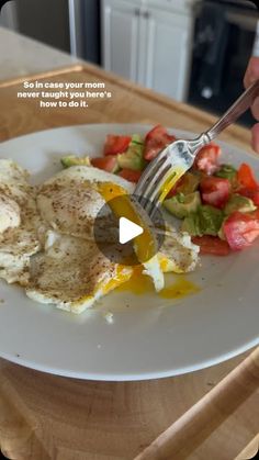 a person is eating an omelet on a plate with a fork and knife