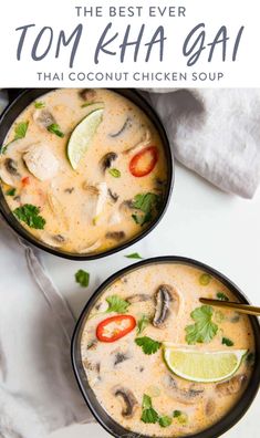 two bowls filled with thai chicken soup and topped with cilantro, lime wedges