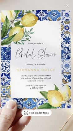 a hand holding up a blue and yellow floral bridal shower card with watercolor flowers on it