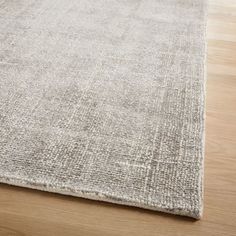 an area rug with wooden flooring on the side and light colored wood in the background