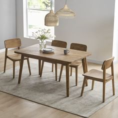 a dining room table and chairs with a rug on the floor in front of it