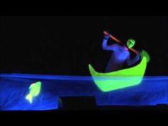 a man in a canoe is illuminated by blue light at the end of his body