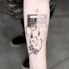 a black and white photo of a person's arm with a tattoo on it