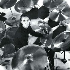 a man sitting in front of a bunch of drums on top of a drum set