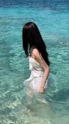 a woman is standing in the clear blue water