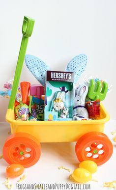 a yellow wagon filled with lots of toys sitting on top of a white table next to confetti