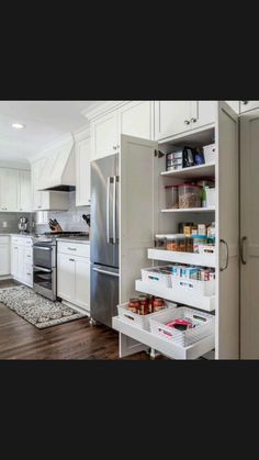 an organized kitchen with white cabinets and drawers