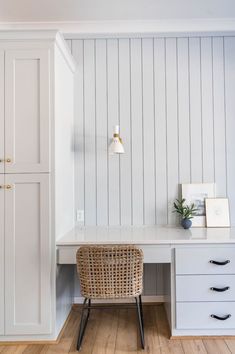 a white desk with a wicker chair next to it