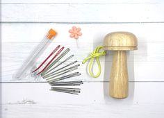 a collection of sewing tools and accessories on a white wooden surface