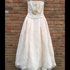 a white dress hanging on a brick wall