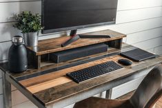 a computer monitor sitting on top of a wooden desk next to a keyboard and mouse