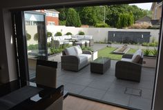 an outdoor living room with patio furniture and large sliding glass doors