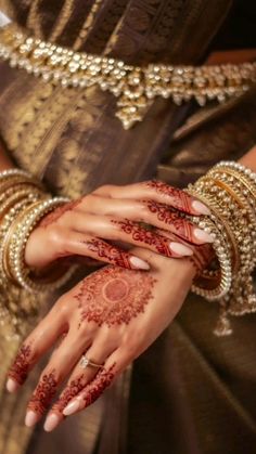 a woman's hands with hennap and bracelets