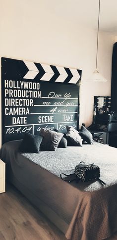 a bedroom with a large bed and a movie sign on the wall