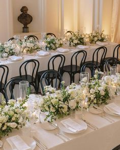 the table is set with white flowers and place settings for guests to sit down at