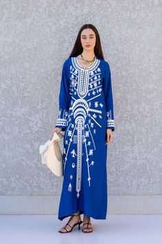 "**Note : The kaftan in the video is a different color of the exact same Kaftan and is only displayed to show the fit, flow, and cut of the Kaftan. You will receive the one in the pictures.** This beautiful Kaftan with the Siwa inspired embroidery is a bohemian and flashy dress that will catch everyone's eyes. it is a show stopper. This Kaftan is ideal to wear for any casual occasion. Whether taking a trip down the shopping lane, or home-based kitty parties, or about anything else, wearing this Traditional Blue Embroidered Beach Dress, Traditional Blue Embroidered V-neck Dress, Blue Long Kaftan With Dabka Detailing, Embroidered Maxi Length Blue Abaya, Blue Traditional Long Thobe, Traditional Blue Long Thobe, Blue Embroidered Long Abaya, Traditional Long Blue Thobe, Embroidered Blue Long Sleeve Abaya