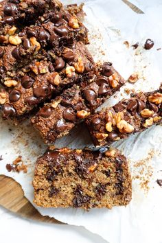 chocolate chip cookie bars cut into squares and stacked on top of each other next to a wooden cutting board