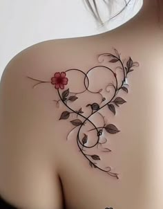 the back of a woman's shoulder with flowers and vines on it