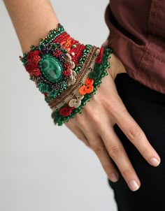 a close up of a person's hand wearing a bracelet with flowers on it