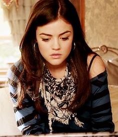 a young woman sitting at a table looking down