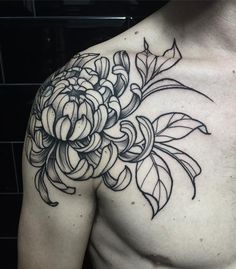 a black and white photo of a man's chest with a flower tattoo on it