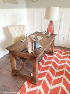 a living room with an orange and white rug on the floor next to a wooden coffee table